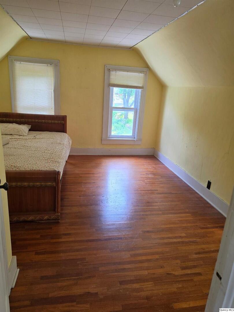 304 West 3rd Street Golden, IL 62339 - Photo 13 of 18 a view of an empty room with wooden floor and a window