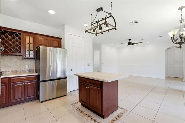 a large kitchen with stainless steel appliances kitchen island granite countertop a refrigerator and a sink