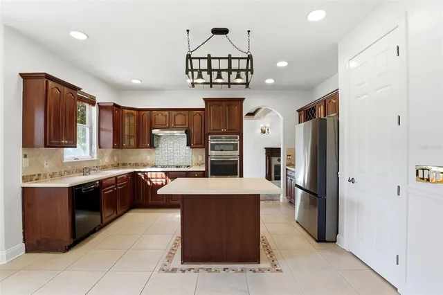 a kitchen with stainless steel appliances granite countertop a sink dishwasher stove and refrigerator with wooden floor