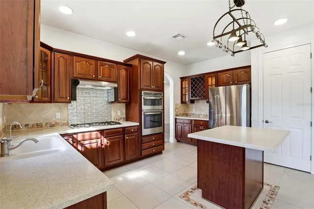 a kitchen with stainless steel appliances granite countertop a refrigerator and a sink