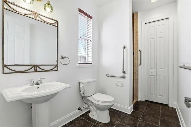a bathroom with a toilet a sink and mirror