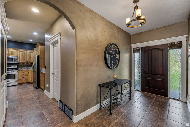 288 525 South Providence, UT 84332 - Photo 12 of 71 Entryway featuring a dark wood arched-top front door, frosted sidelight windows, and tile flooring