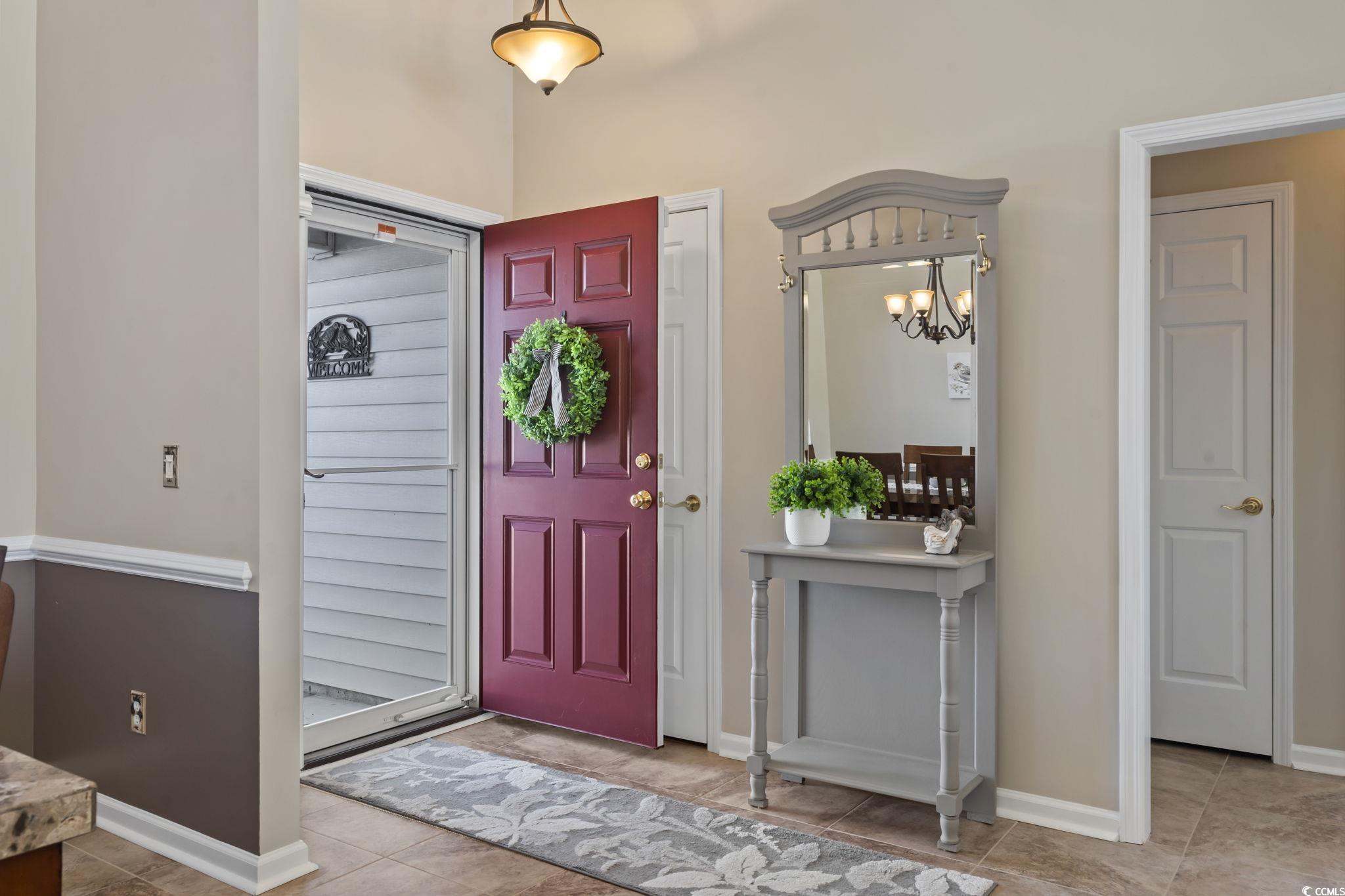 Foyer with tile patterned floors and an inviting c