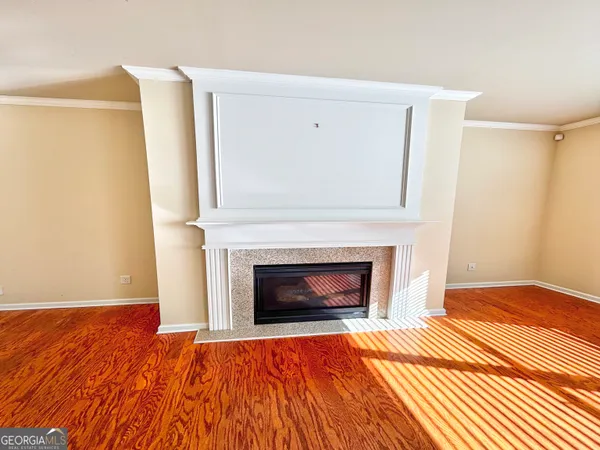 a view of a livingroom with wooden floor and a fireplace