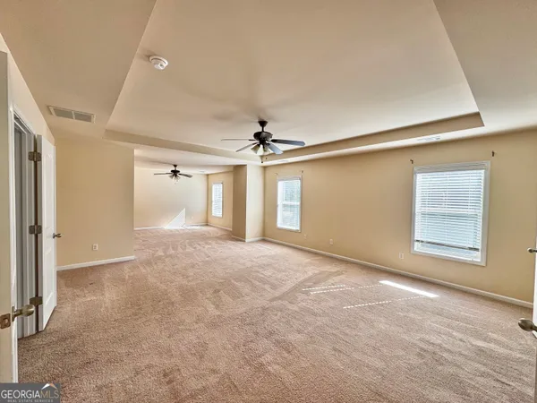 a view of a livingroom with a ceiling fan and window
