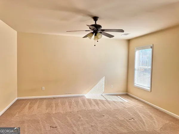 a view of a room with a ceiling fan and a window