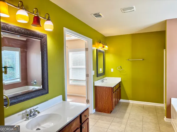 a bathroom with a sink mirror and a bathtub