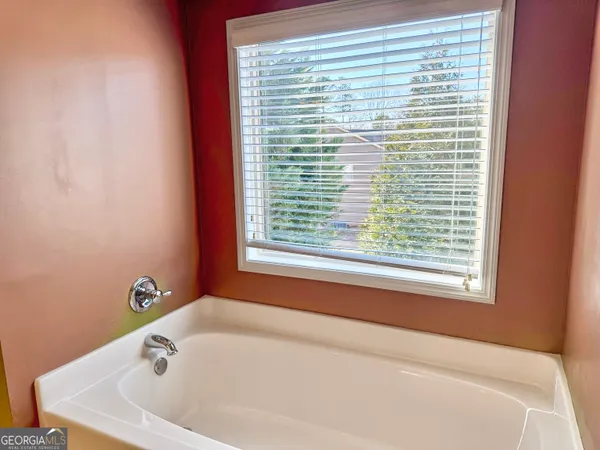 a white bath tub sitting in a bathroom next to a window