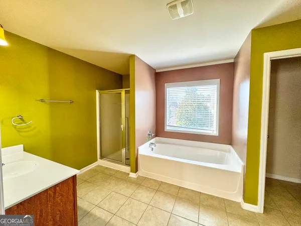 a spacious bathroom with a tub shower and sink