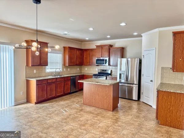 a kitchen with stainless steel appliances granite countertop a refrigerator a sink dishwasher a oven and a dining table with wooden floor