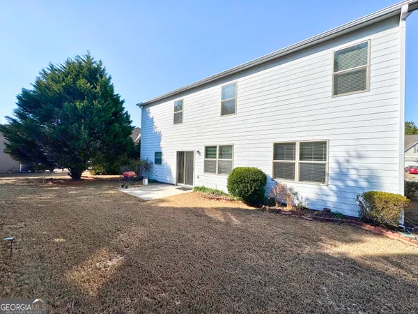 a view of a house with backyard and a garage