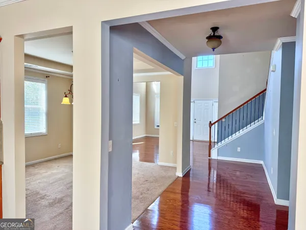 a view of hallway with wooden floor and stairs