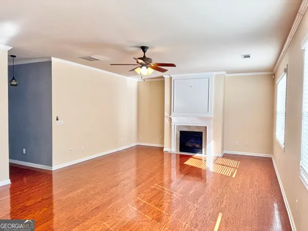 a view of a livingroom with a fireplace a ceiling fan and entryway