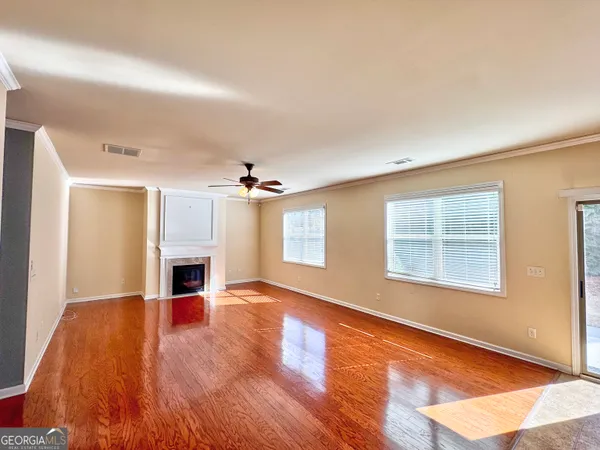 an empty room with windows and fireplace