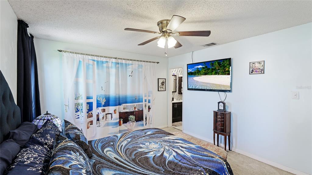 13492 Dibella Avenue Port Charlotte, FL 33981 - Photo 19 of 37 a bedroom with a bed furniture and a flat screen tv