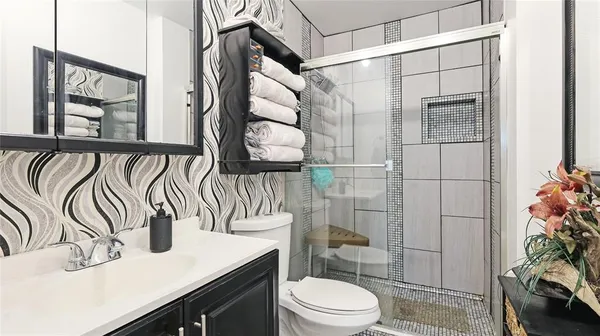 a bathroom with a sink a toilet and shower