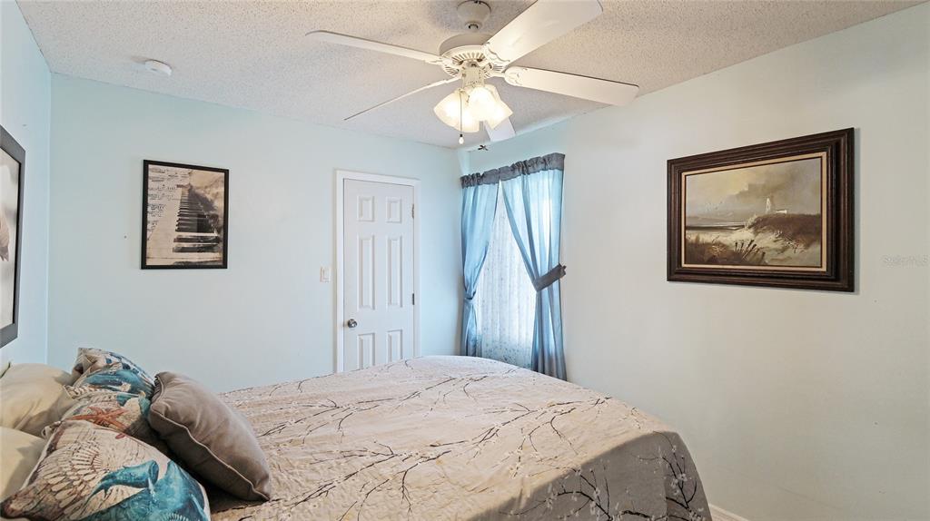 13492 Dibella Avenue Port Charlotte, FL 33981 - Photo 22 of 37 a bedroom with a bed and a chandelier