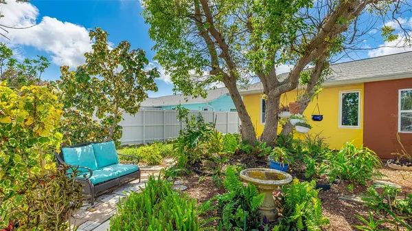 a view of a garden with chairs and potted plants
