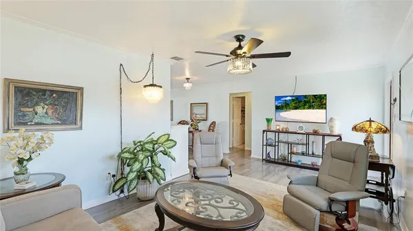 a living room with furniture a chandelier and a window
