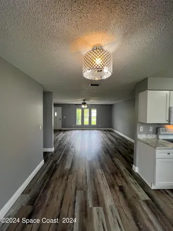 a view of a livingroom with wooden floor and a ceiling fan