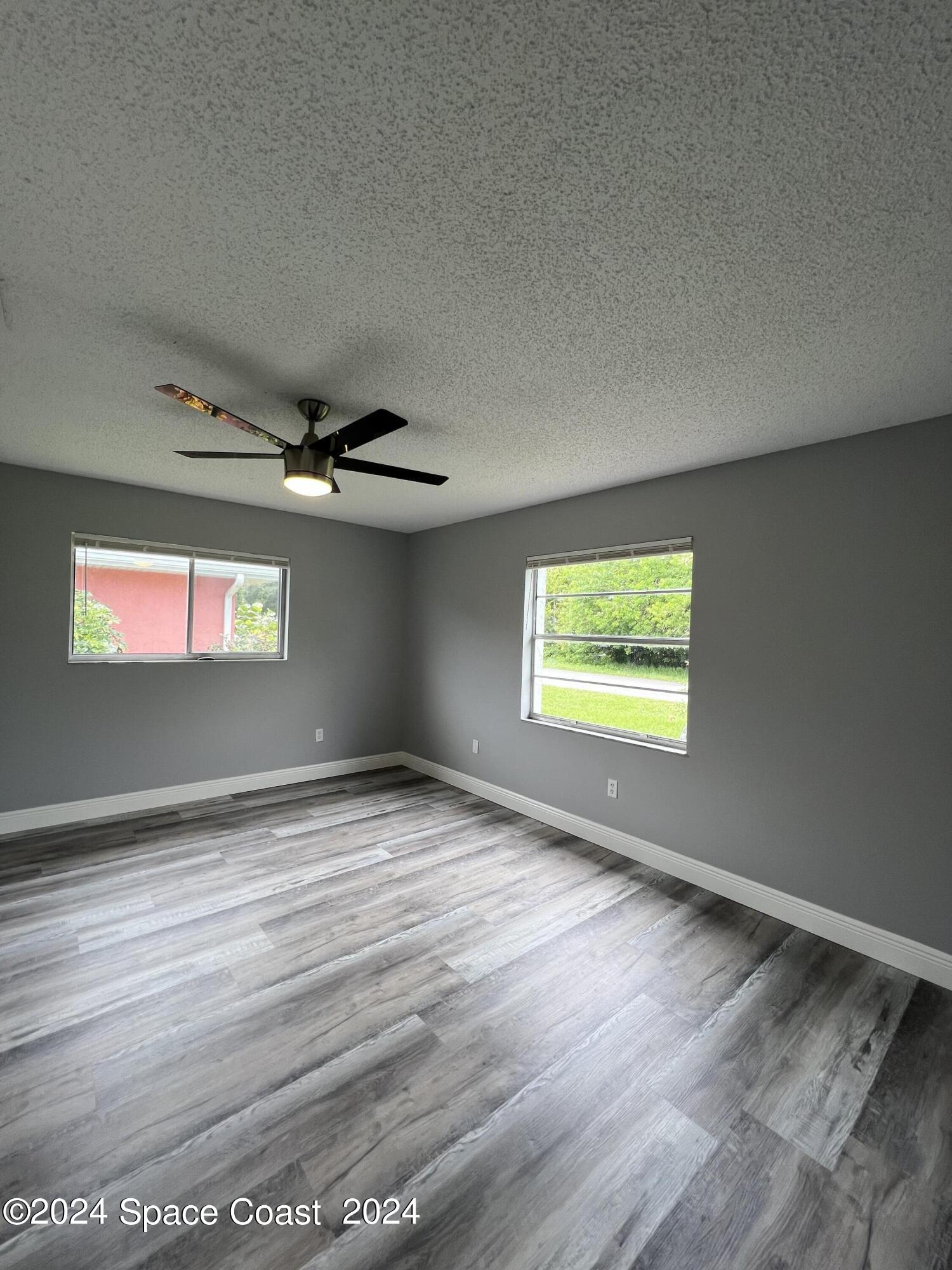 219 Capron Road Cocoa, FL 32927 - Photo 13 of 21 a view of an empty room with wooden floor and windows
