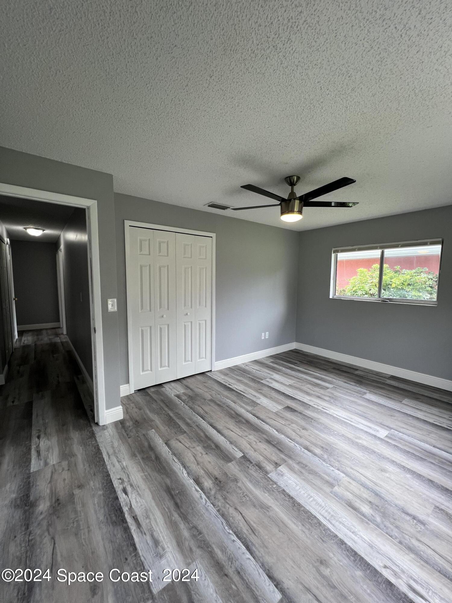 219 Capron Road Cocoa, FL 32927 - Photo 14 of 21 a view of a livingroom with wooden floor and a ceiling fan