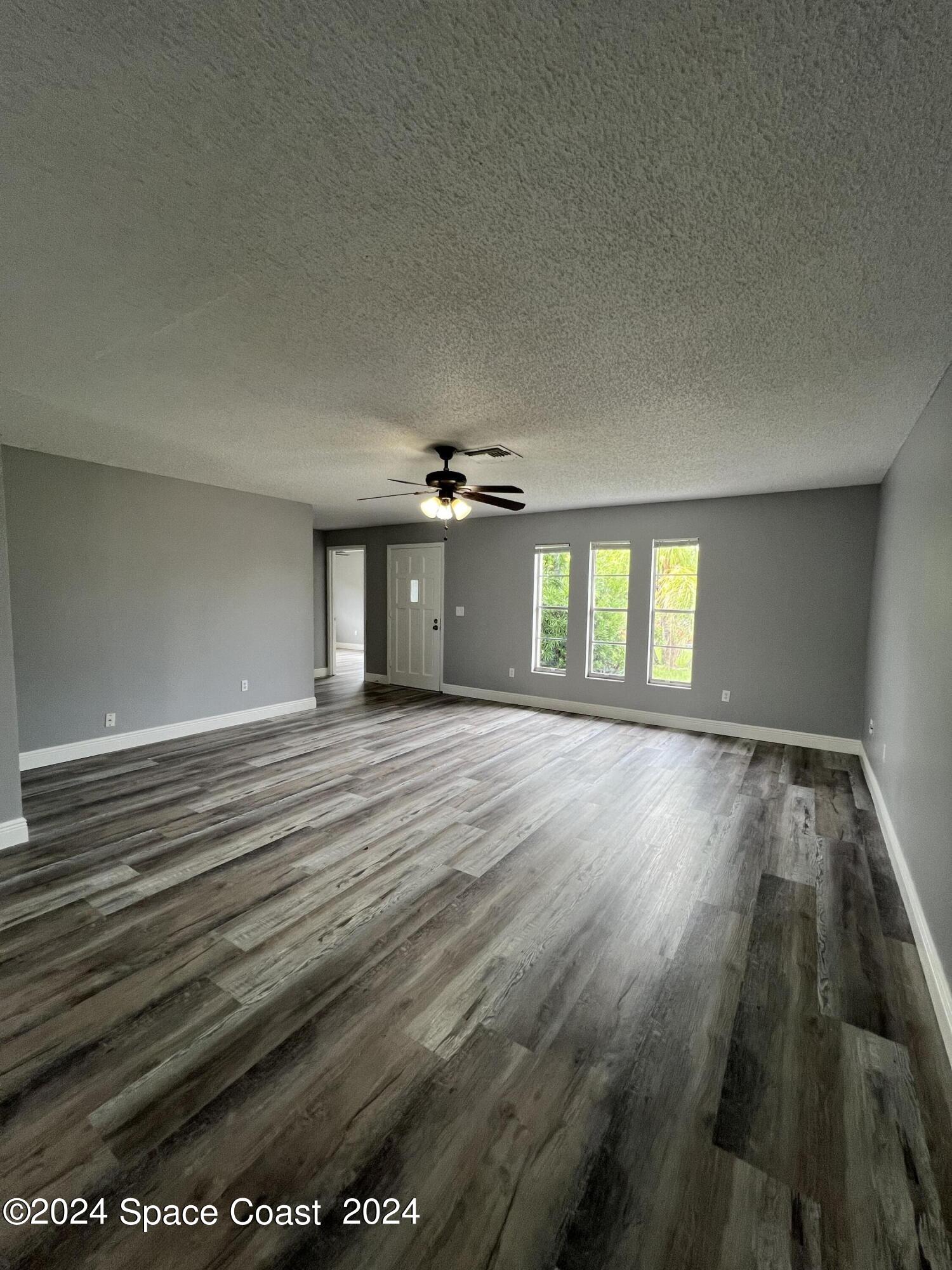 219 Capron Road Cocoa, FL 32927 - Photo 6 of 21 wooden floor in an empty room with a window