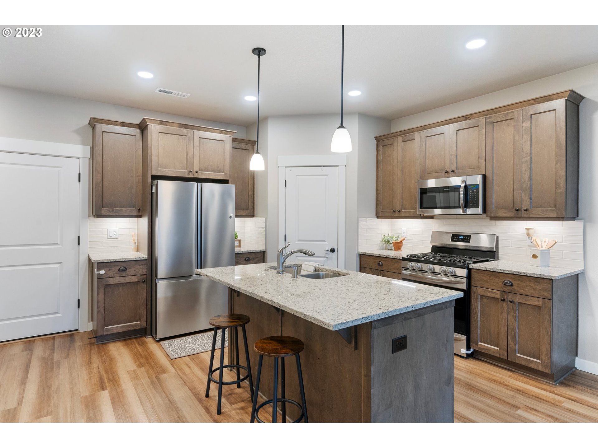 7176 South 13th Street Ridgefield, WA 98642 - Photo 8 of 46 a kitchen with kitchen island a refrigerator stove and microwave