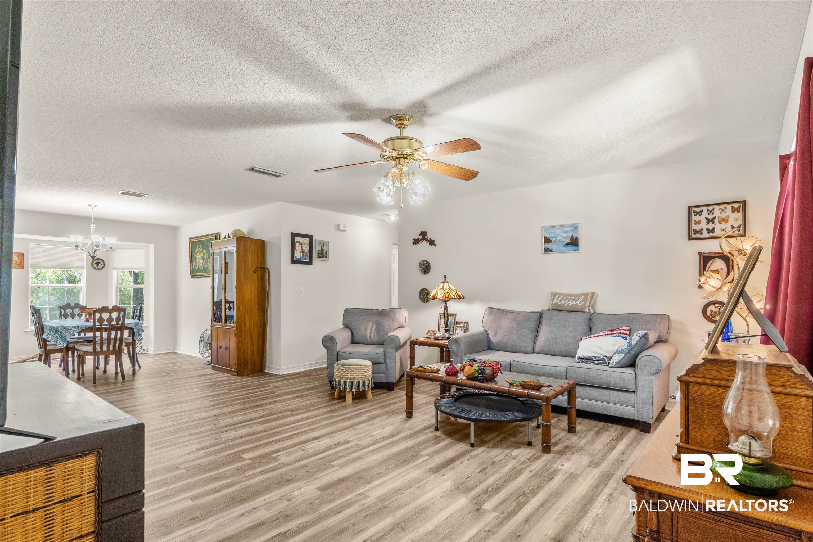 35893 Pine Road South Stapleton, AL 36578 - Photo 8 of 31 Spacious living area featuring wood-finish flooring, a ceiling fan with integrated lighting, and white baseboards