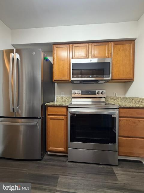 8393 Montgomery Run Road, Unit H Ellicott City, MD 21043 - Photo 15 of 30 a kitchen with granite countertop a refrigerator stove and microwave