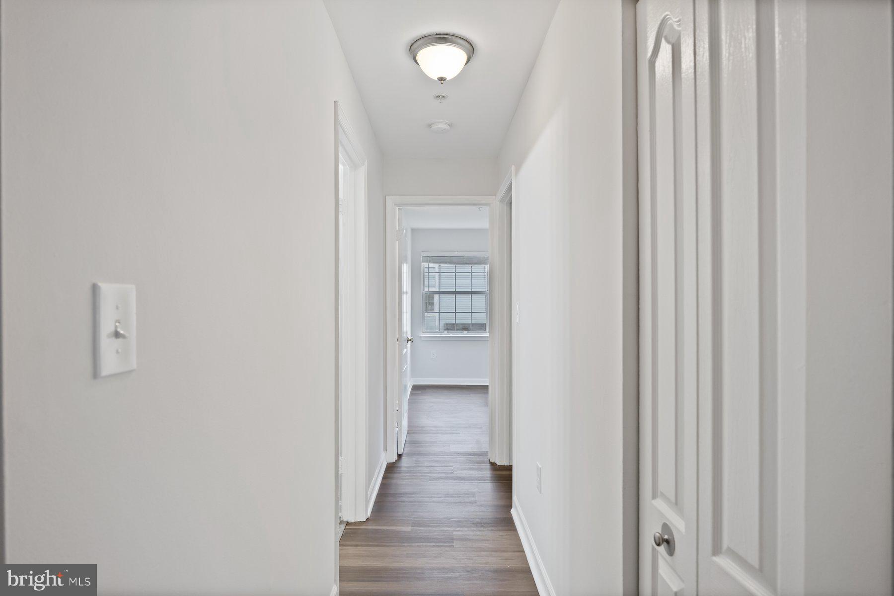 8393 Montgomery Run Road, Unit H Ellicott City, MD 21043 - Photo 17 of 30 a view of a hallway with wooden floor