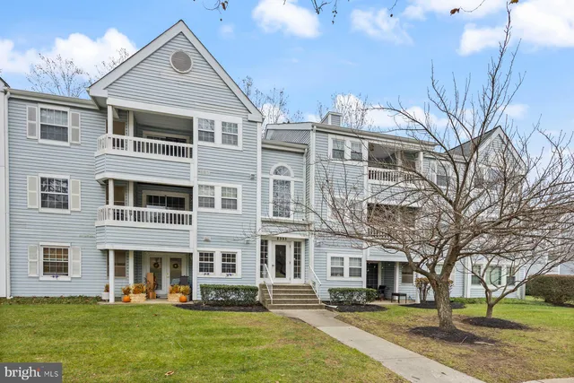 a front view of residential houses with yard and green space