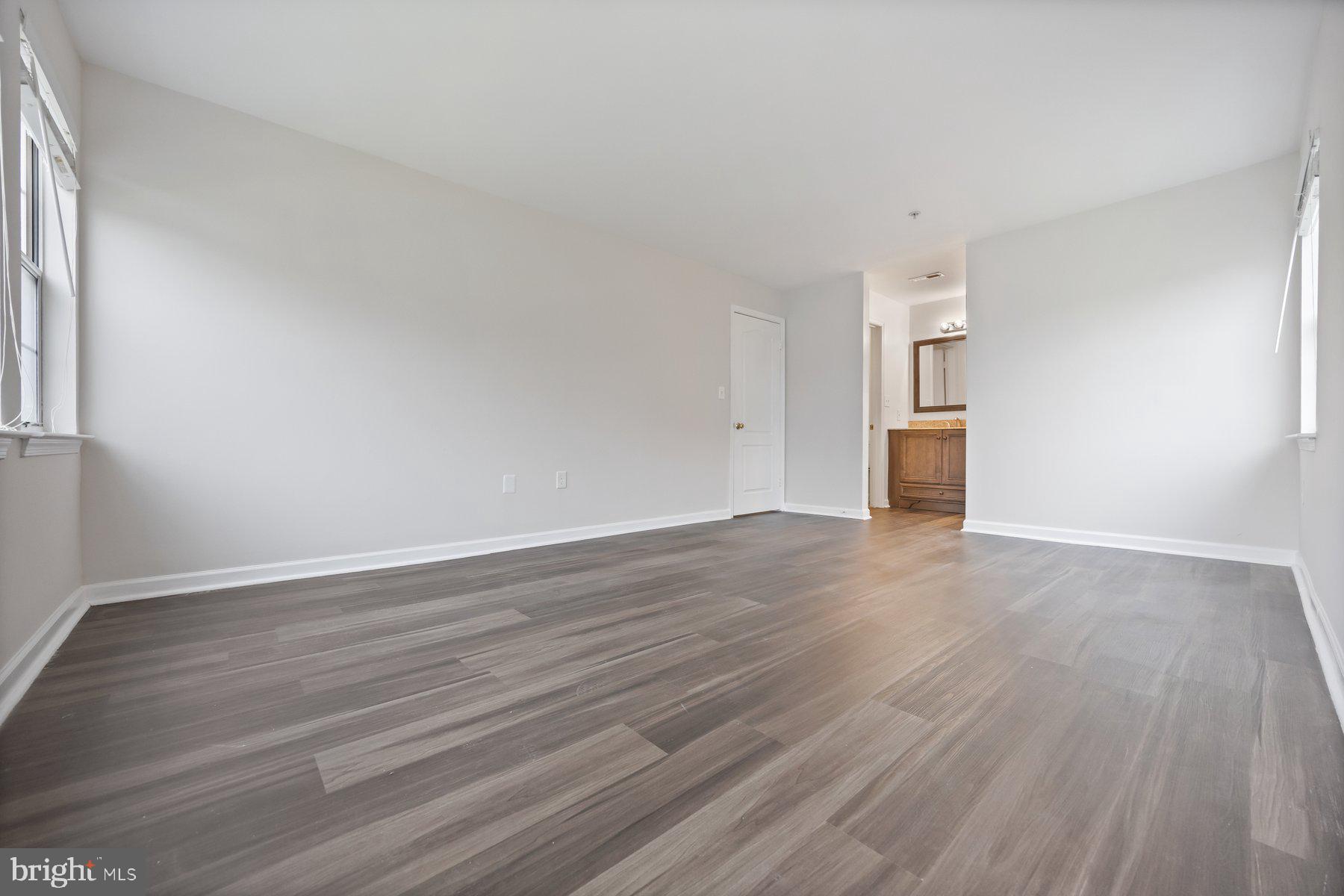 8393 Montgomery Run Road, Unit H Ellicott City, MD 21043 - Photo 21 of 30 a view of an empty room with wooden floor and a window