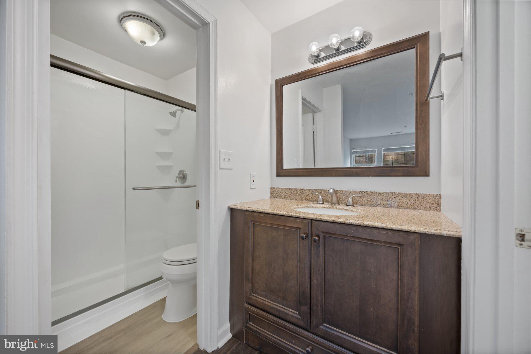 8393 Montgomery Run Road, Unit H Ellicott City, MD 21043 - Photo 23 of 30 a bathroom with a toilet sink shower and mirror