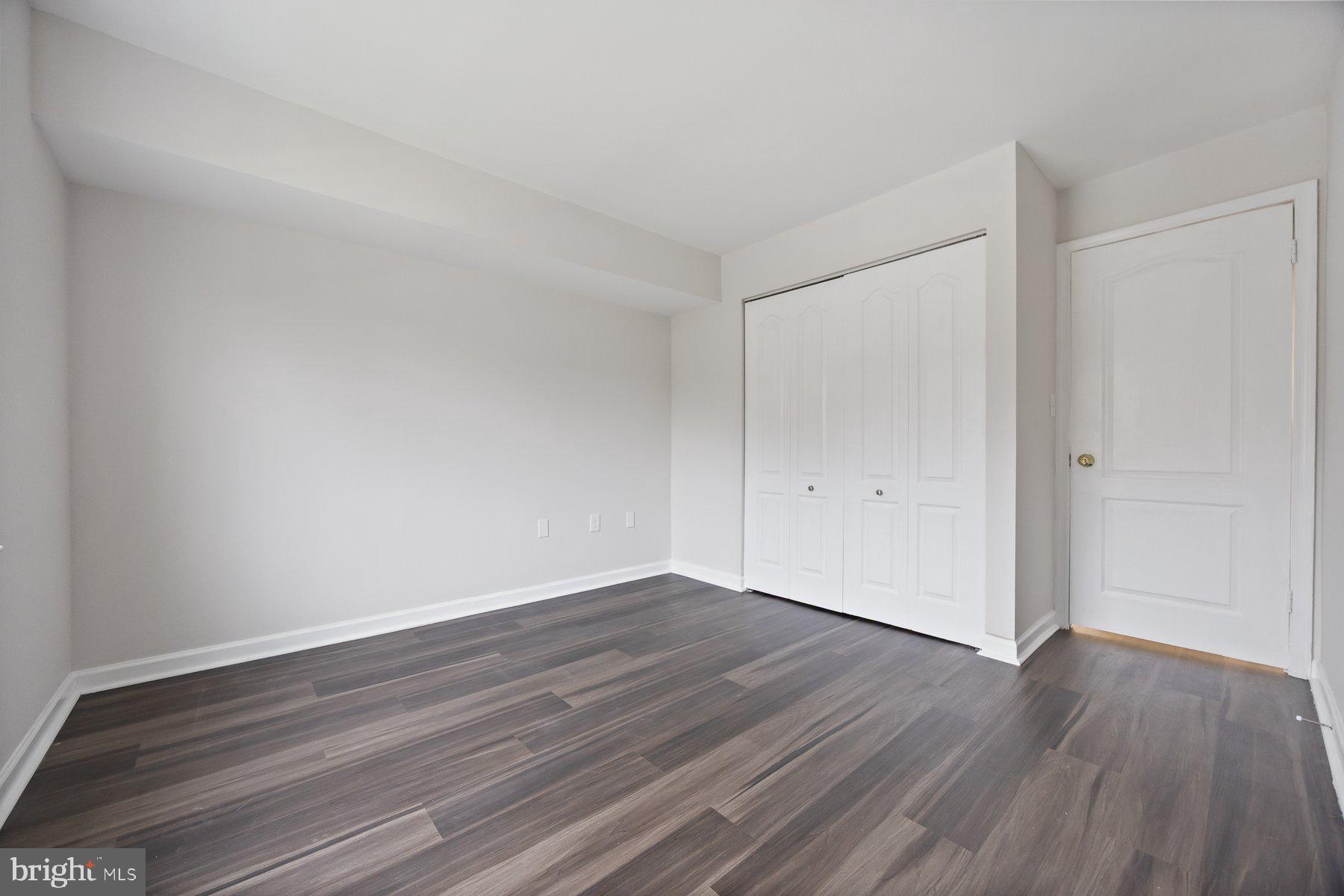 8393 Montgomery Run Road, Unit H Ellicott City, MD 21043 - Photo 27 of 30 a view of an empty room with wooden floor