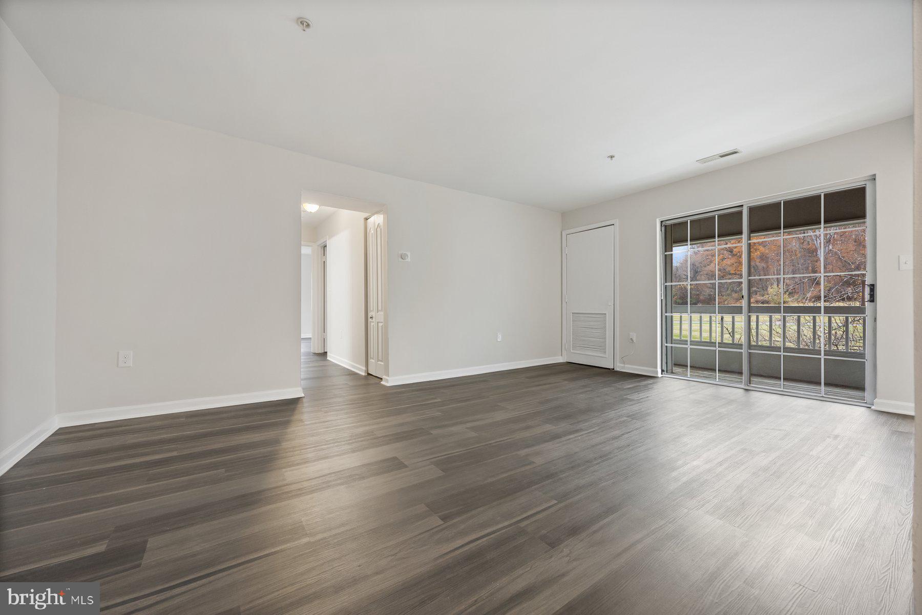 8393 Montgomery Run Road, Unit H Ellicott City, MD 21043 - Photo 6 of 30 a view of an empty room with wooden floor and a window