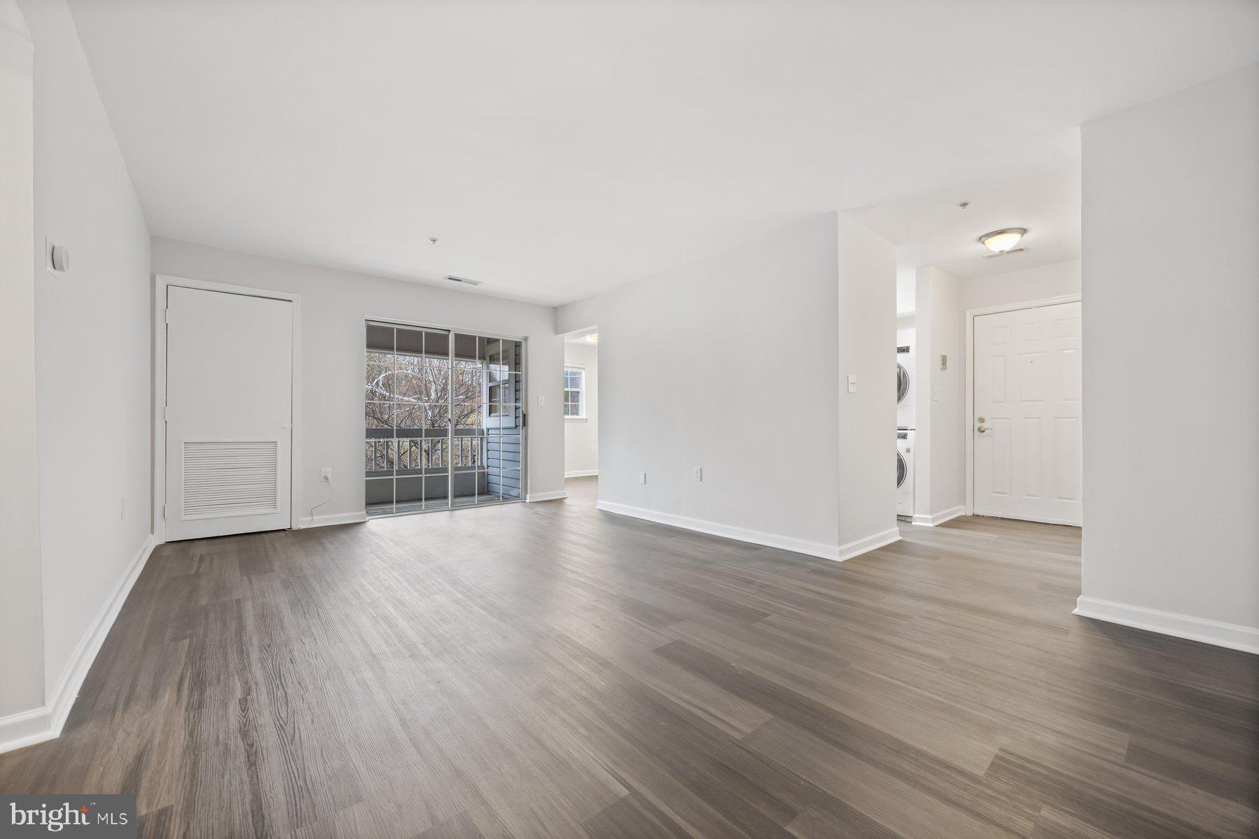 8393 Montgomery Run Road, Unit H Ellicott City, MD 21043 - Photo 7 of 30 an empty room with wooden floor and windows