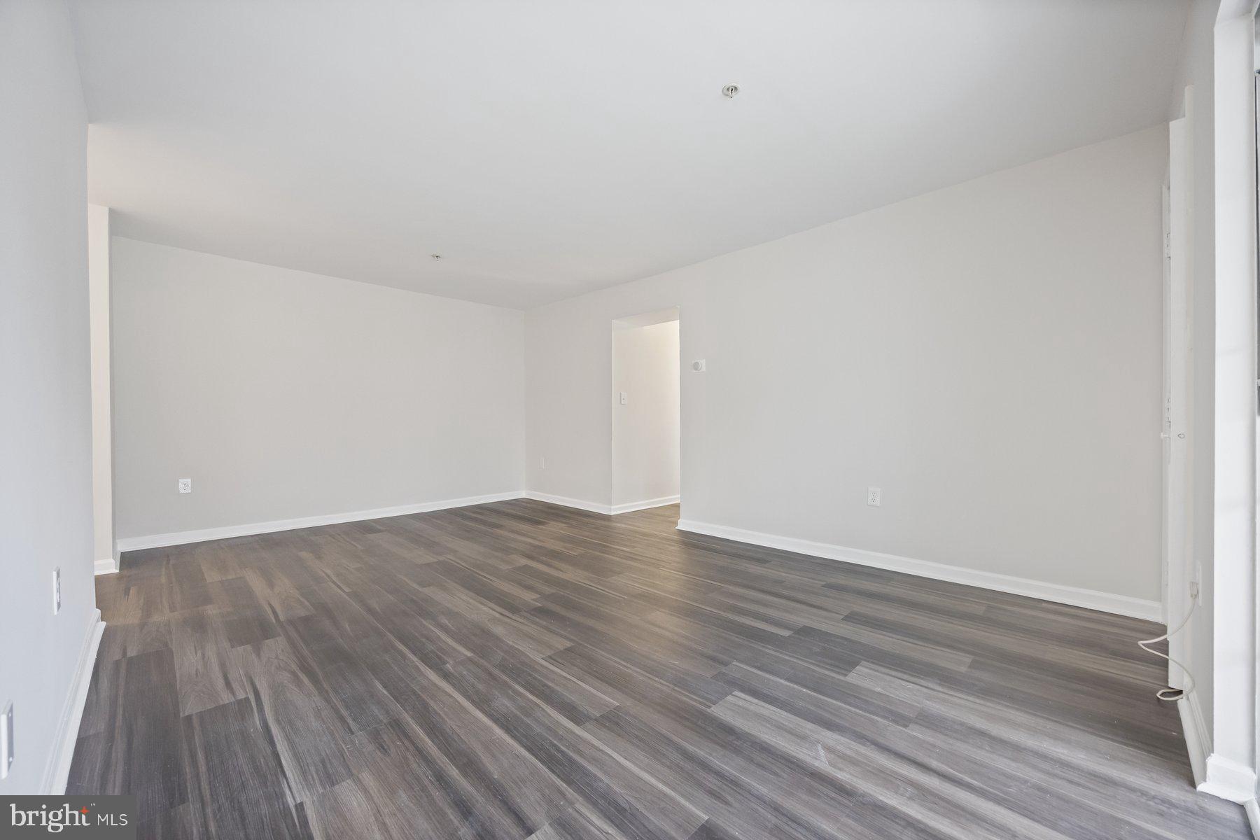 8393 Montgomery Run Road, Unit H Ellicott City, MD 21043 - Photo 9 of 30 a view of an empty room with wooden floor