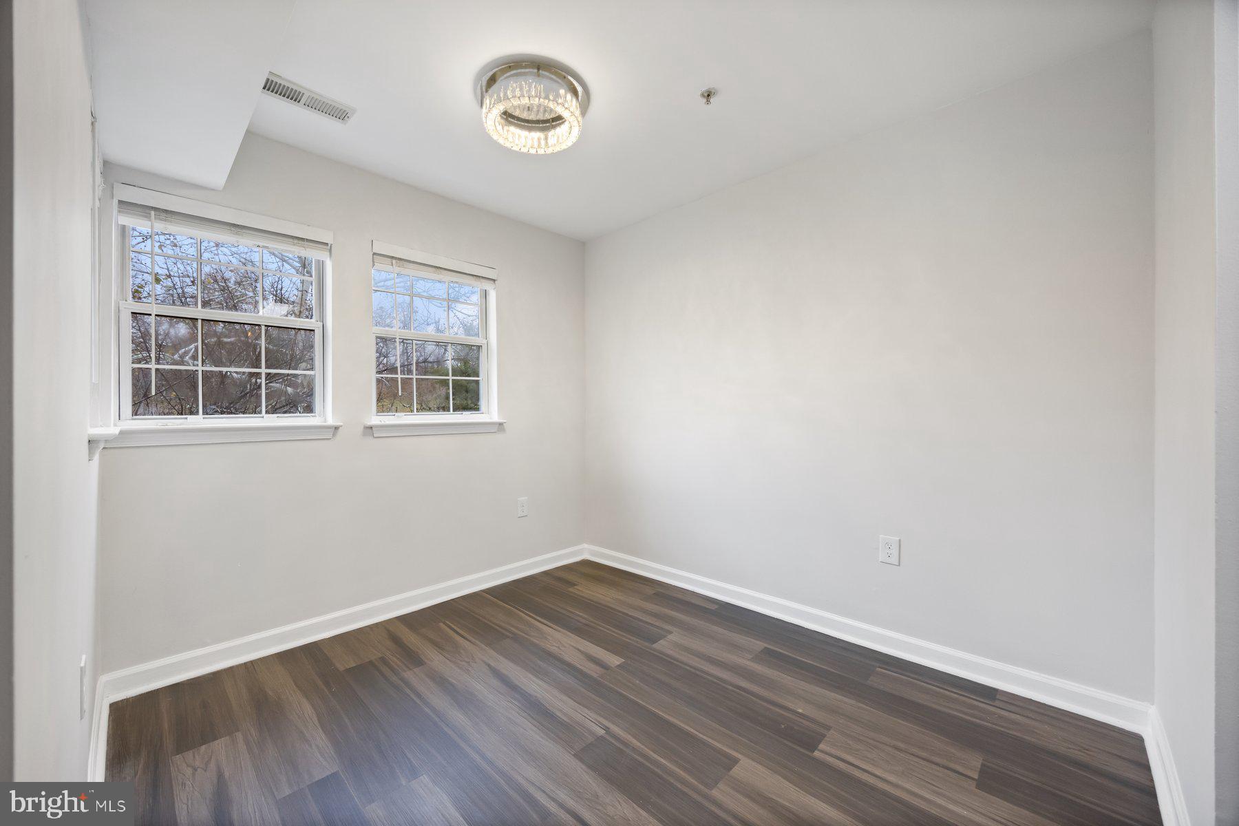 8393 Montgomery Run Road, Unit H Ellicott City, MD 21043 - Photo 10 of 30 an empty room with wooden floor and windows