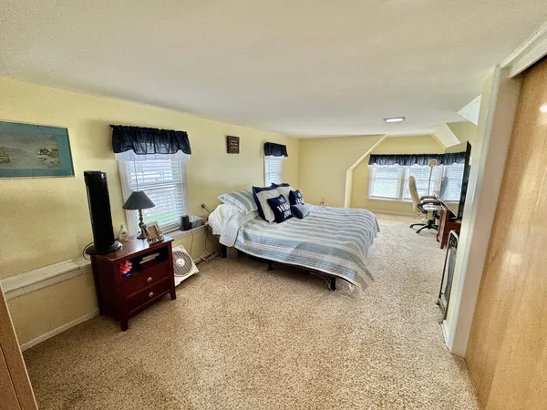 a bedroom with a bed and large windows