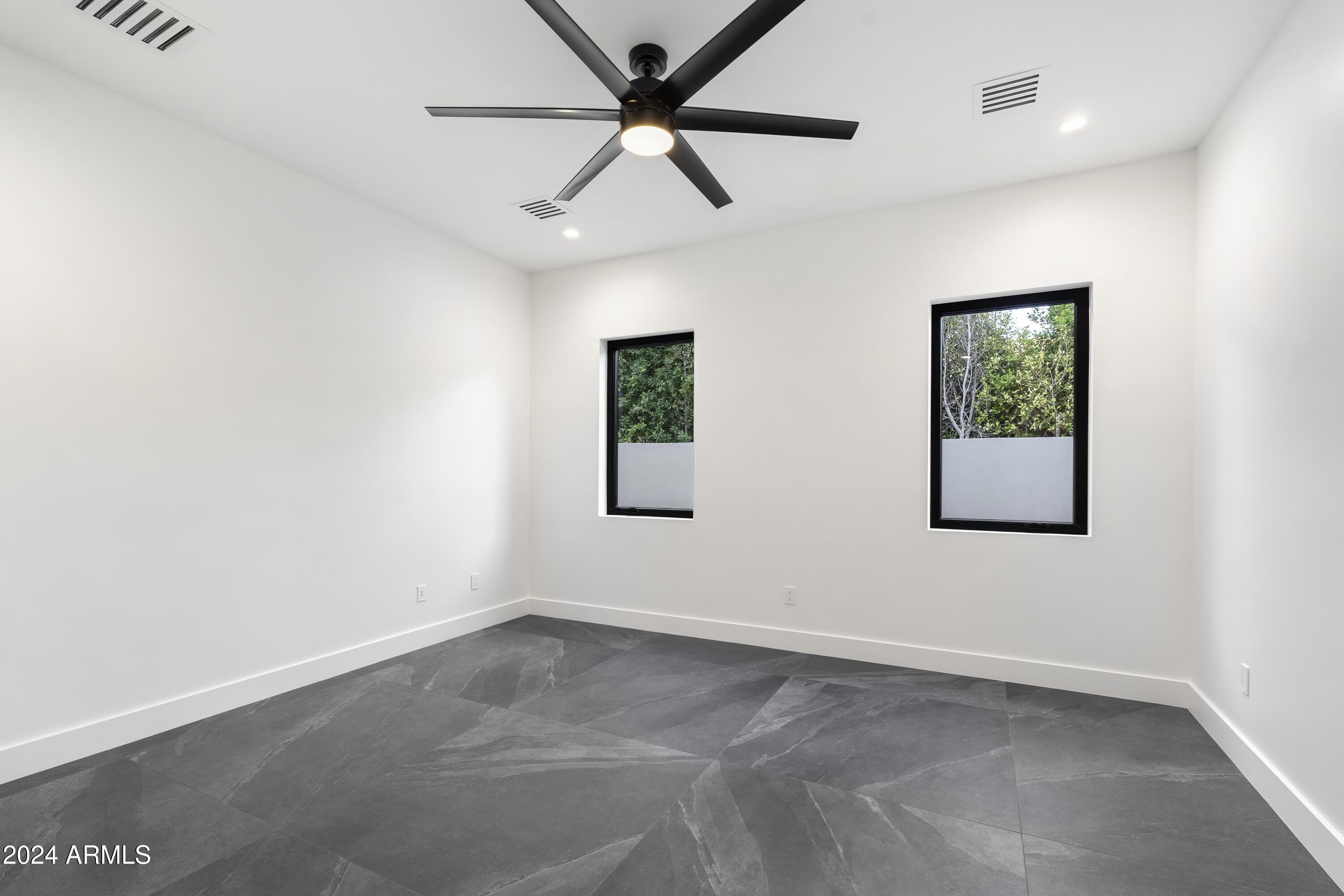 8037 North 7th Avenue Phoenix, AZ 85021 - Photo 27 of 40 an empty room with a window and a ceiling fan