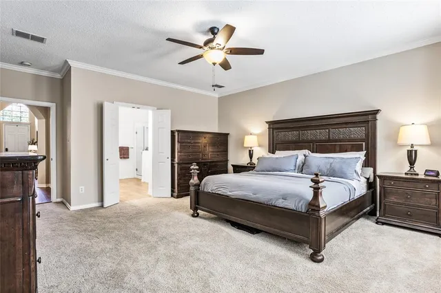 a spacious bedroom with a bed and a ceiling fan