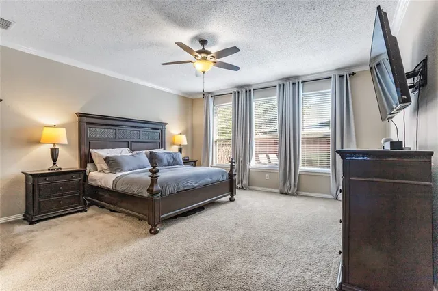 a bedroom with a large bed and a flat tv screen on dresser