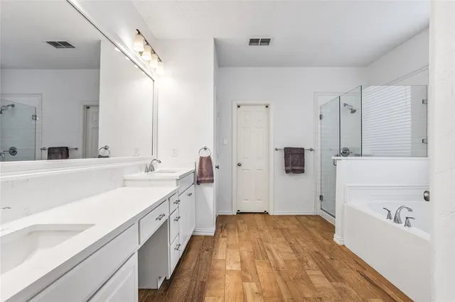a bathroom with a sink a large mirror and a bathtub
