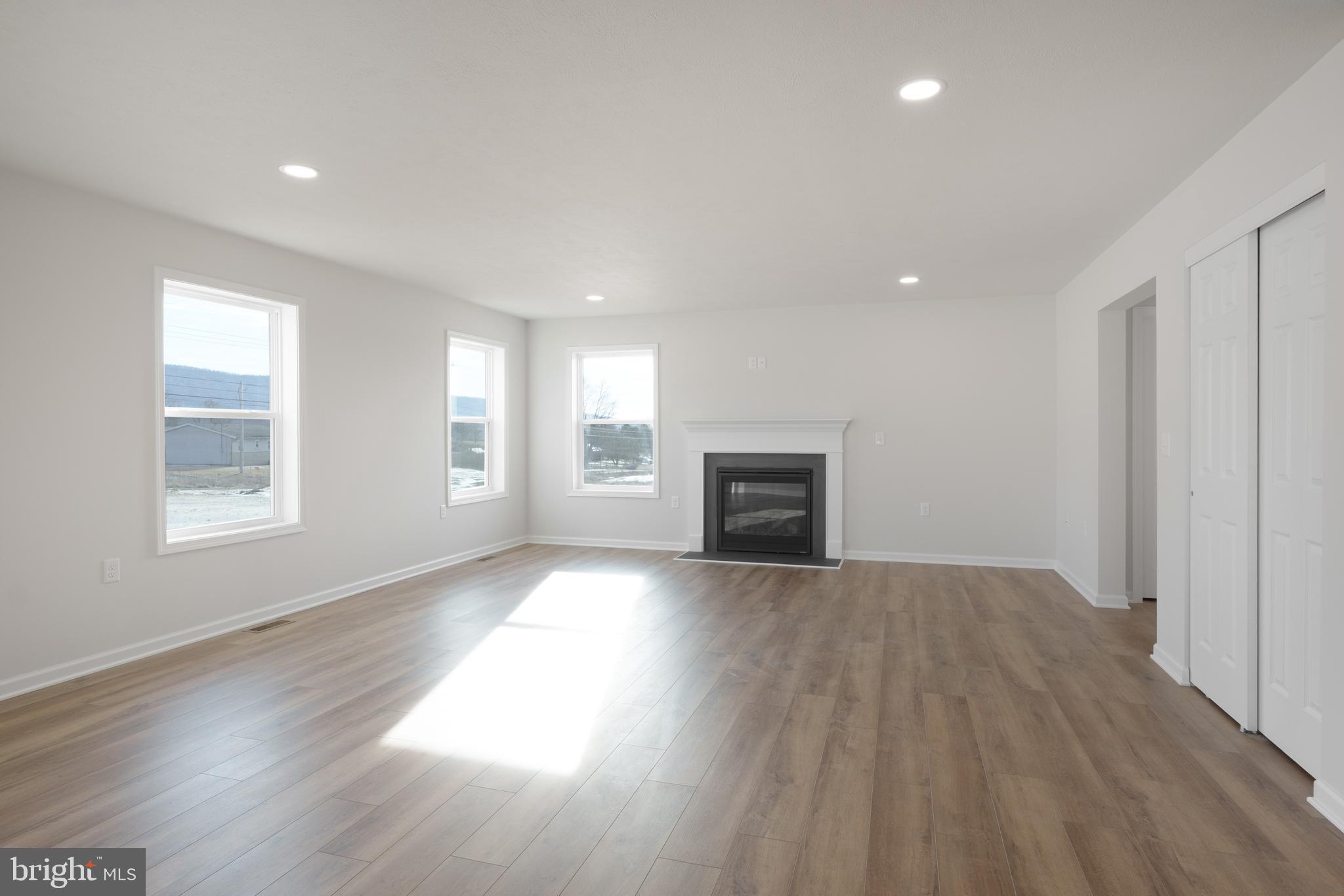 170 Ten Point Path Bellefonte, PA 16823 - Photo 13 of 45 an empty room with wooden floor fireplace and windows