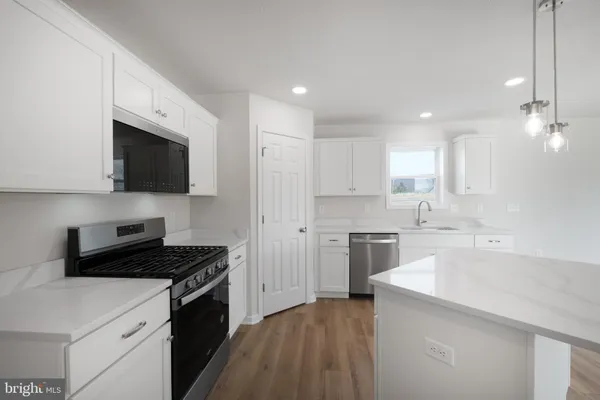 a kitchen with a sink a stove a microwave and cabinets
