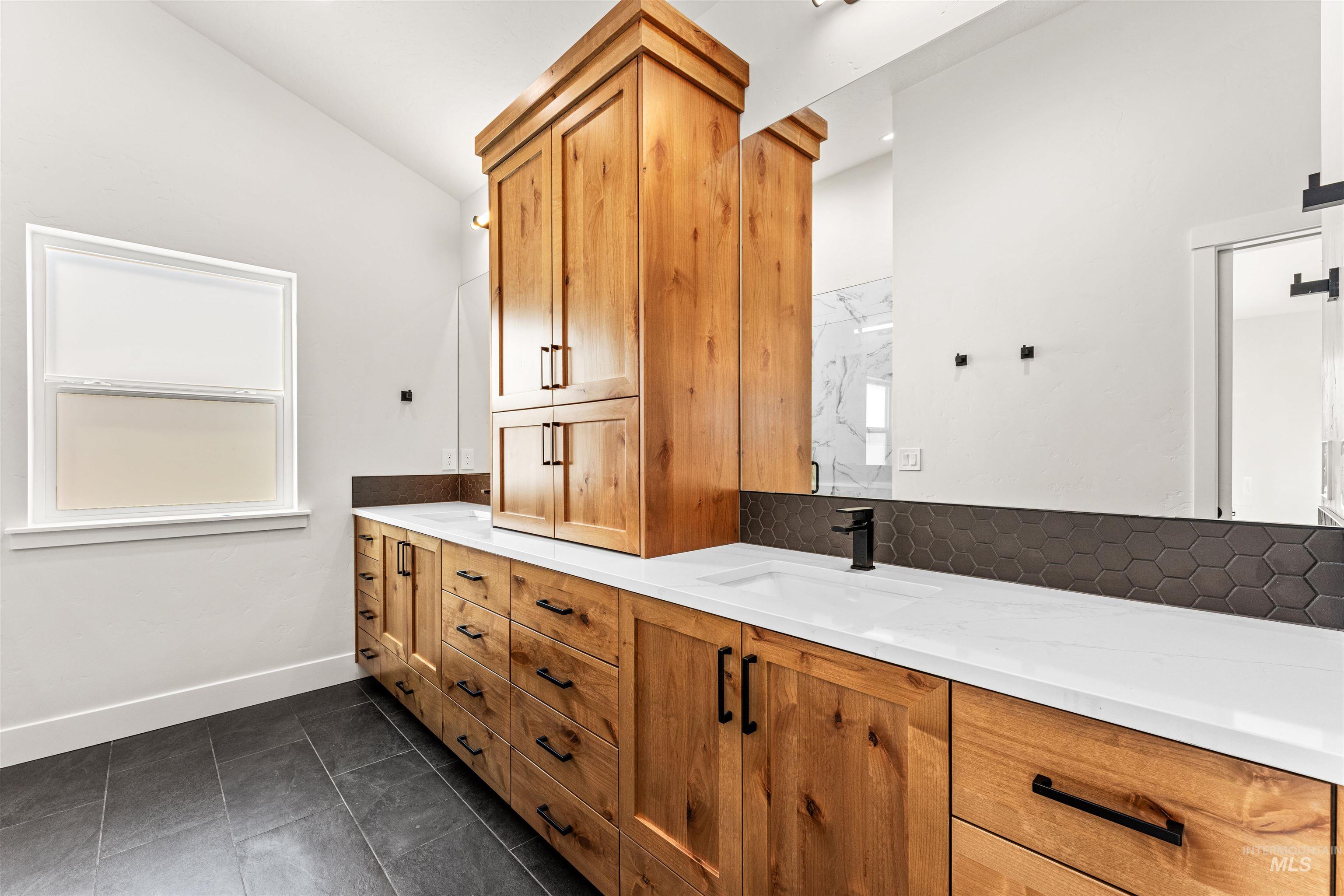 2709 West Gidran Meridian, ID 83642 - Photo 22 of 43 Double vanity with wood-finish cabinetry, integrated sinks, white countertops, and matte black hardware