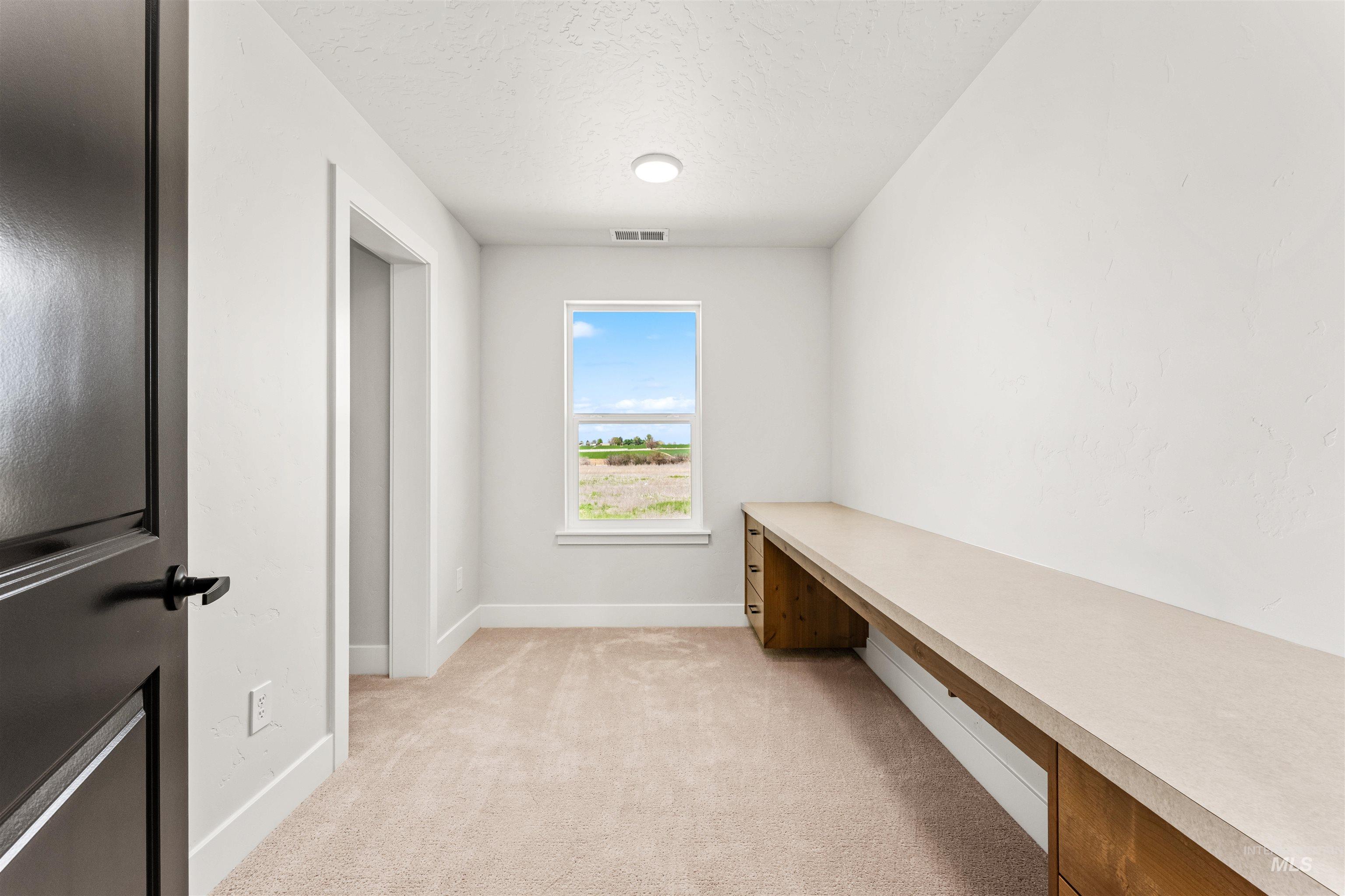 2709 West Gidran Meridian, ID 83642 - Photo 26 of 43 Room featuring a built-in desk with multiple drawers, light-colored countertop, and a window