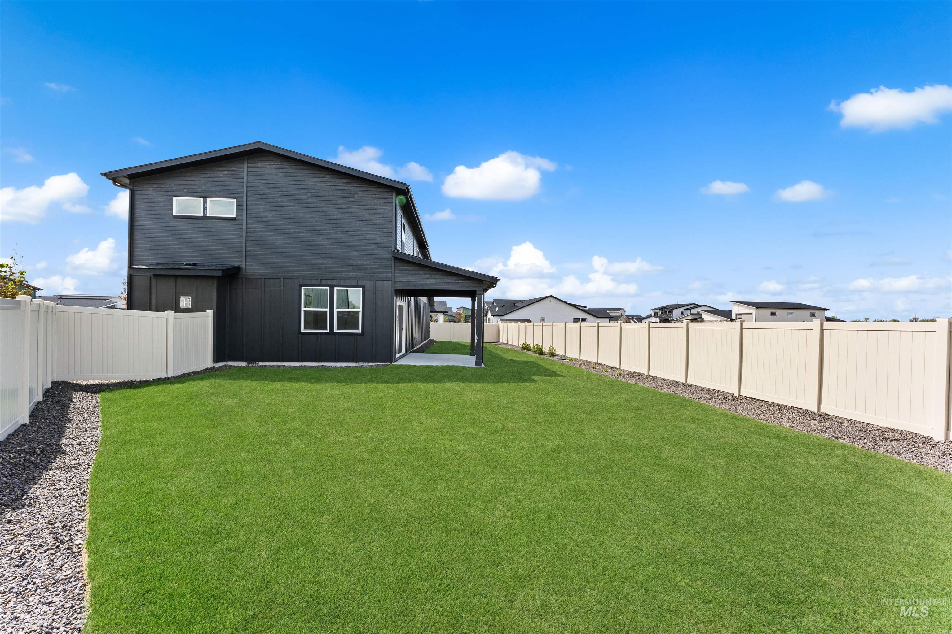 2709 West Gidran Meridian, ID 83642 - Photo 39 of 43 Expansive backyard featuring a large lawn area, full perimeter fencing, and a covered concrete patio