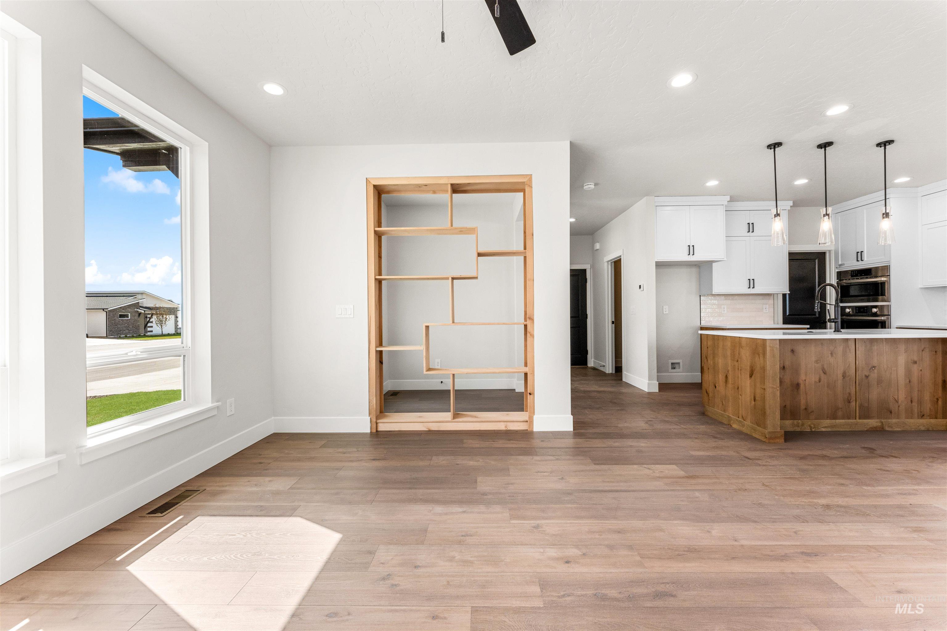 2709 West Gidran Meridian, ID 83642 - Photo 7 of 43 Open-concept living space featuring wide plank wood-finish flooring and a built-in wooden shelving unit
